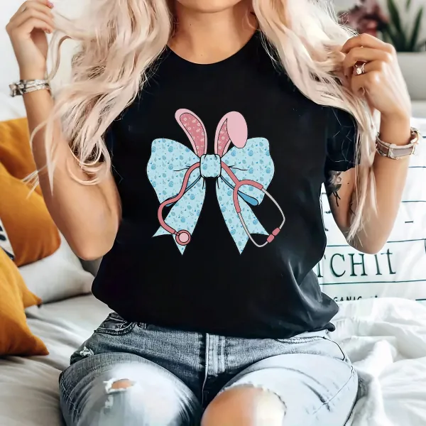 A Cartoon Rabbit Ear Element Bow Pattern, The Bow Has Blue Dots, The Rabbit Ears Are Pink With White Dots And A Pink Stethoscope Pattern, Casual T-Shirt