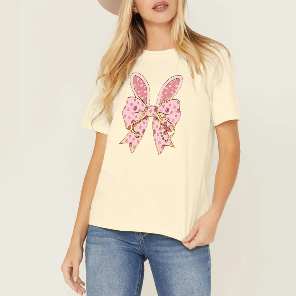 A Pink Bow Pattern With Bunny Ears And Pink Polka Dots, Hanging On A Golden Stethoscope And A Casual T-Shirt.