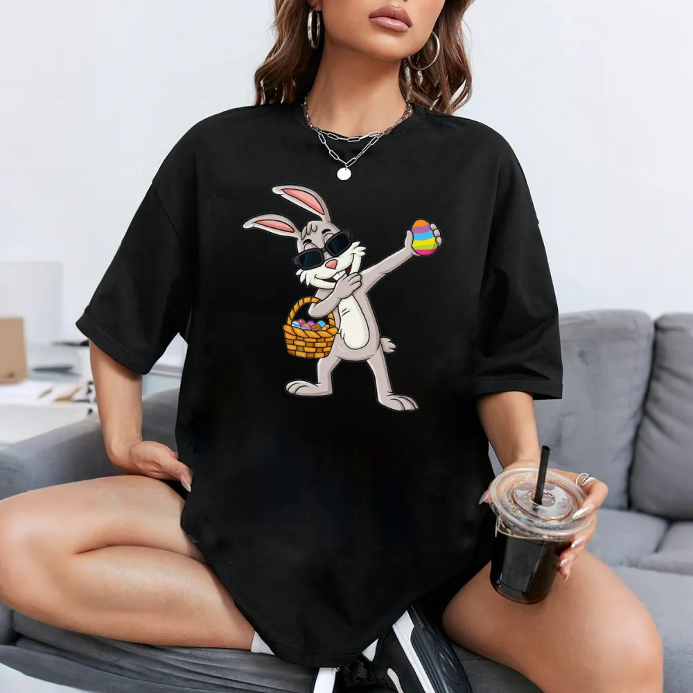 A Cartoon Rabbit Wearing Black Sunglasses, Holding A Colorful Easter Egg, With A Basket Full Of Eggs Next To The Other Hand. The Style Is Playful And Cute, With A Casual T-Shirt.