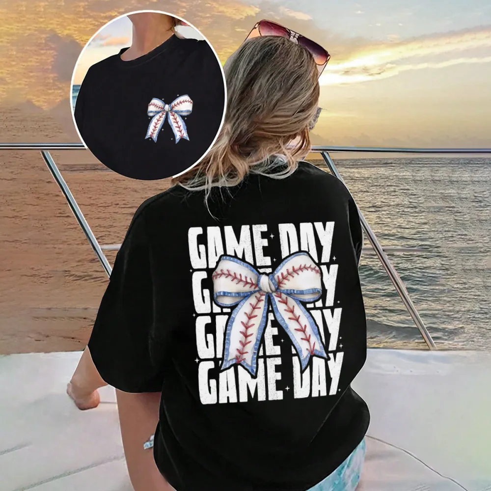 A Casual T-Shirt With Repeated Letters “GAME DAY” And A Bow Pattern In The Middle Designed In The Style Of Baseball Stitching.